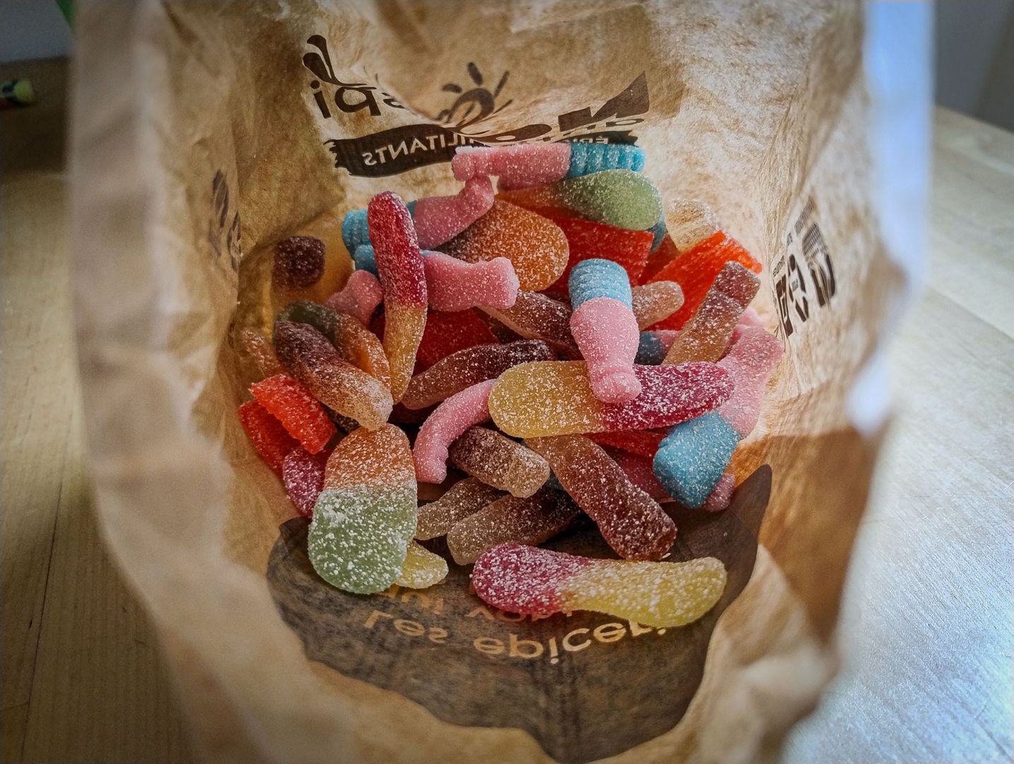 A shot of the inside of a brown paper bag filled with various coloured and sugared sweets