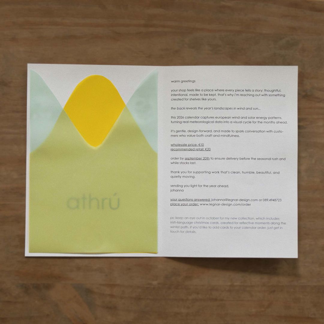 the image shows an opened brochure laying on a woodesn desk. on the left hand side are two overlapping shapes of translucent paper and the irish word 'athrú' underneath. on the right hand side is a letter set in black lower case letters.